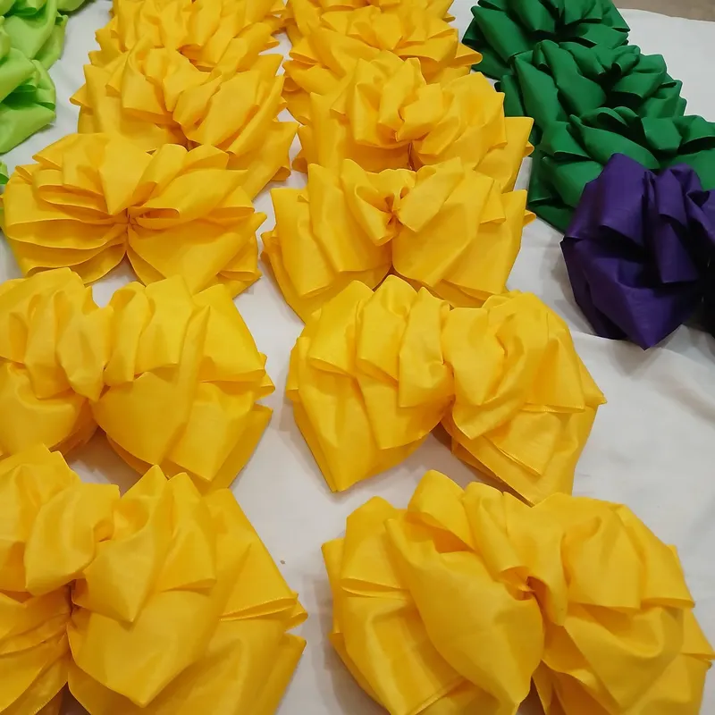 Docenas de lazos de satín en amarillo, verde y morado