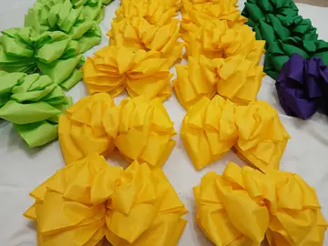 Docenas de lazos de satín en amarillo, verde y morado