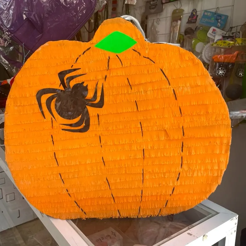 Piñata de calabaza naranja con una araña pintada