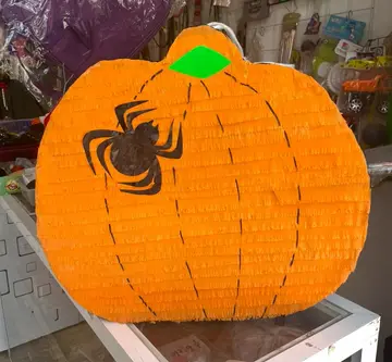 Piñata de calabaza naranja con una araña pintada