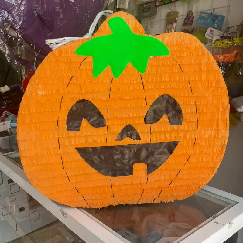 Piñata de calabaza naranja con cara sonriente
