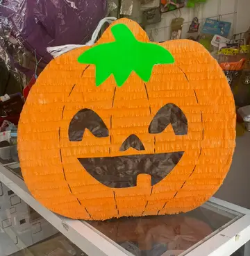 Piñata de calabaza naranja con cara sonriente