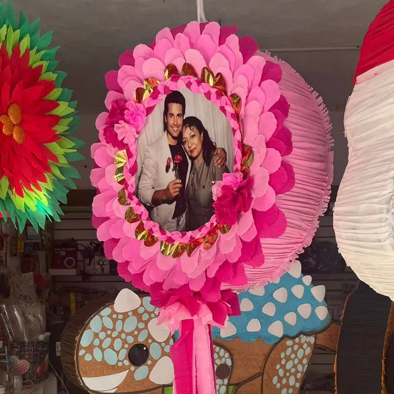 Piñata circular rosa con una fotografía al centro