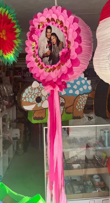 Piñata circular rosa con una fotografía al centro