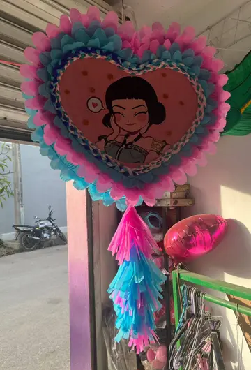 Piñata de corazón con un personaje al centro
