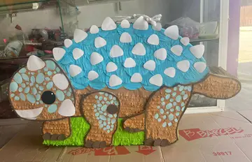 Piñata de dinosaurio azul con placas blancas