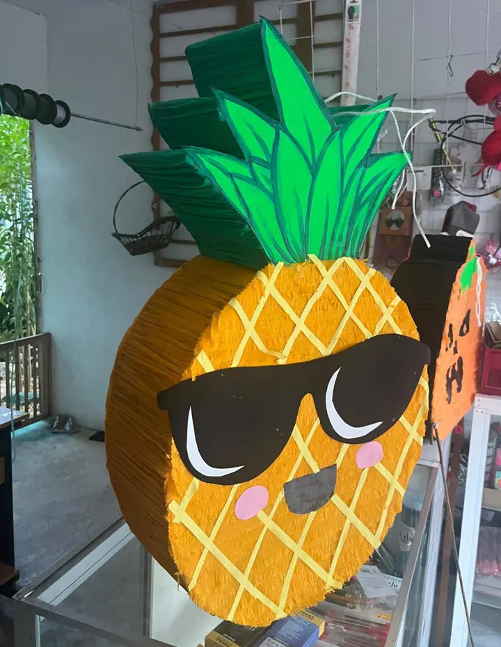 Piñata de piña amarilla con lentes negros