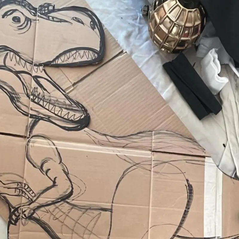 Trazo del dinosaurio dibujado sobre cartón antes de recortarlo