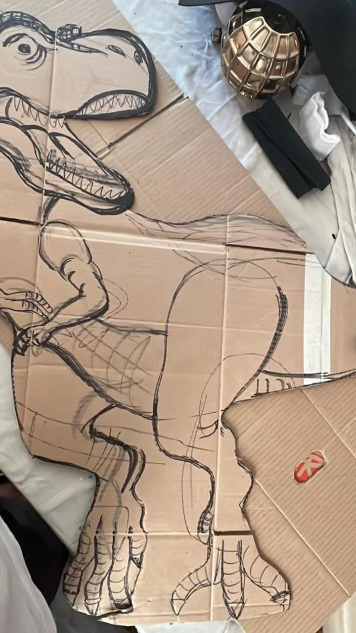 Trazo del dinosaurio dibujado sobre cartón antes de recortarlo
