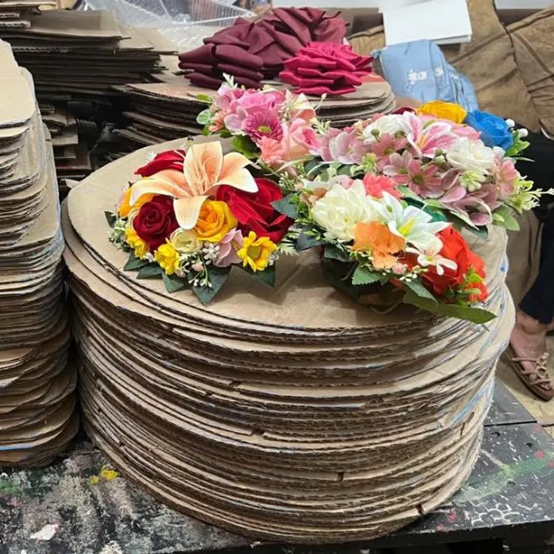 Tapas de cartón apiladas junto a flores de tela