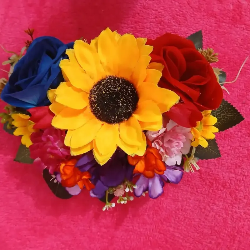Tocado con un girasol grande y rosas azules y rojas